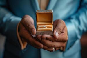 Close up of man holding an engagement ring box photo