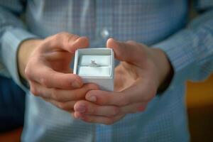 Close up view of man holding an engagement ring box photo