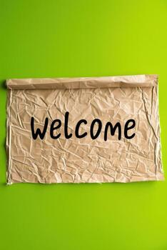 un Bienvenido firmar en estropeado papel en ligero verde antecedentes foto