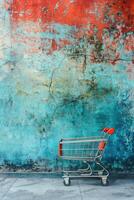Shopping cart against a weathered blue and red wall. photo