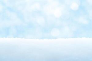 Light blue winter background with snow drifts and bokeh photo