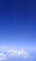 Vertical gradient blue sky with white fluffy clouds photo