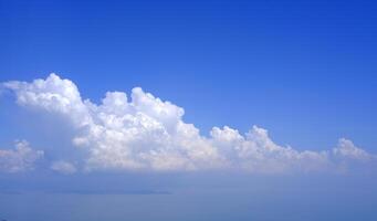 Horizontal gradient blue sky with white fluffy clouds photo