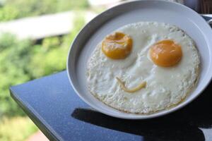 Fried eggs with smiling happy face at hotel's restaurant photo