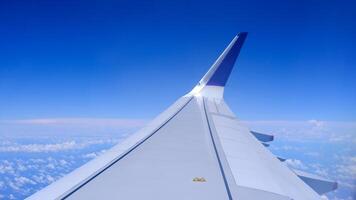 Horizontal air plane with gradient blue sky and white fluffy clouds photo
