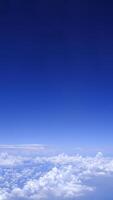 Vertical gradient blue sky with white fluffy clouds photo