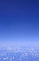 Vertical gradient blue sky with white fluffy clouds photo