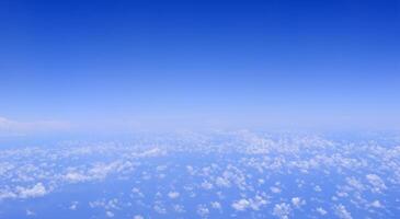 Horizontal gradient blue sky with white fluffy clouds photo