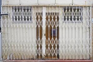 Traditional retro Hong Kong style shop front building metal gate white rolling gate and door design photo
