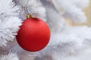 Close up view of a white artificial Christmas tree decorated with red balls photo