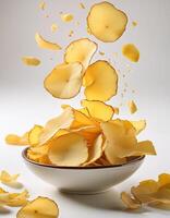 Slight yellow color cassava chips falling into a bowl on white background, food photo studio concept with white background