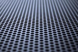Metallic surface with regular round holes. Industrial background photo