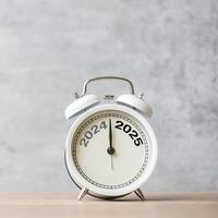 Happy New Year with vintage alarm clock and 2024 change to 2025 number. Merry Christmas, New Start, Resolution, countdown, Goals, Plan, Action and Mission Concept photo