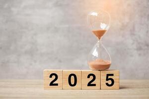 2025 text with hourglass on table. Resolution, time, plan, goal, motivation, reboot, countdown and New Year holiday concepts photo
