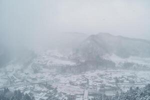 view of village with snow in winter from mountain viewpoint of Yamadera temple, the popular name for the Buddhist temple of Risshakuji located in Yamagata City, in Yamagata Prefecture, Tohuku, Japan photo