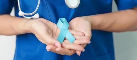 Blue November Prostate Cancer Awareness month, Doctor with Blue Ribbon in hospital for support people life and illness. Healthcare, International men, Father, Diabetes and World cancer day photo