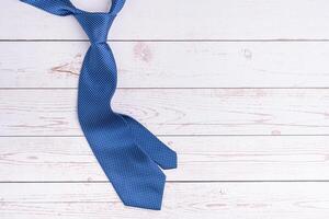 Happy Father's Day with a blue tie on wooden background with space for text. Top view. Flat lay photo