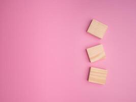 The top view of blank wooden blocks laid an isolated pink background. Space for text. Flat lay. Object concept photo