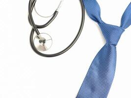 A stethoscope and blue tie laid isolated on a white background. Top view. Flat lay with space for text photo