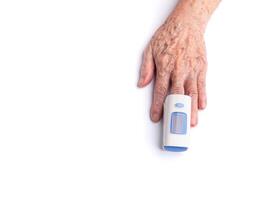 Senior woman finger with a pulse oximeter for testing oxygen levels on a white background. Cose-up photo. Measurement of oxygen level in the blood. Healthcare concept photo
