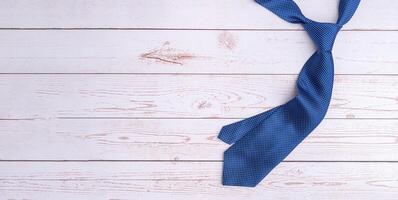 Happy Father's Day with a blue tie on wooden background with space for text. Top view. Flat lay photo