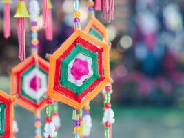 Colorful decorative mobile spider web weaving hanging on a tree. Crafting colorful yarn to use decorations for festivals. Space for text photo