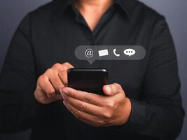 Hands of a businessman using a smartphone with the icon images. Close-up photo. Communication, technology, and business customer support concept photo