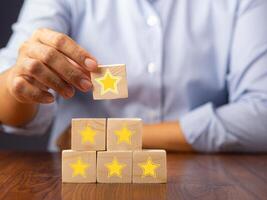 Close-up of hand holding a wooden block with the five-star symbol. Concept of feedback and service serving concept photo