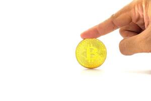 Close-up of finger touching a bitcoin golden coin with a white background. Close-up photo. Space for text. Virtual cryptocurrency and future money concept photo