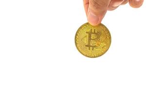 Close-up of hand holding a bitcoin golden coin with a white background. Close-up photo. Space for text. Virtual cryptocurrency and future money concept photo
