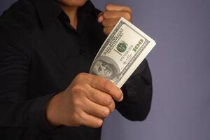 Businessman hand holding of US banknotes and a fist while standing in a studio. Close-up photo. Business and finance concept photo