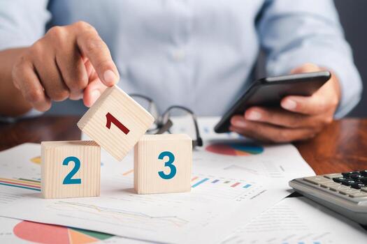Close-up of a hand touching on wooden dice with numbers 1,2,3 are placed on a table in the office. Space for text. Step by step concept photo