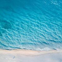 empty abstract sand beach with palm leaf shadow and transparent water wave from above, blank background banner for travel, vacation and wellbeing with copy space. top of views, aerial views. photo