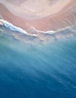 empty abstract sand beach with palm leaf shadow and transparent water wave from above, blank background banner for travel, vacation and wellbeing with copy space. top of views, aerial views. photo