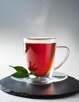 Glass cup of hot aromatic tea with leaves on clear white background photo