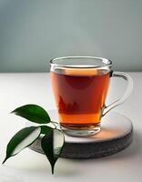Glass cup of hot aromatic tea with leaves on clear white background photo