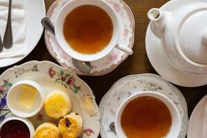 Close up of Scones Strawberry Jam and Butter Served with Hot Tea in Afterernoon photo