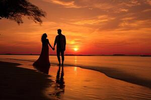 Man and Woman Holding Hands on Beach at Sunset photo