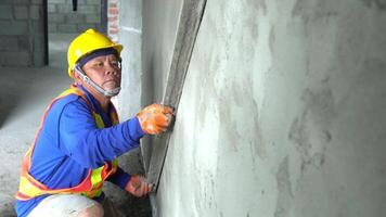 Professional construction work adjusts the level of cement to be even with the wall with expertise in house construction concepts and architectural decoration. video