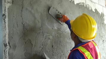 Asian worker uses tools to smooth plaster on a wall Home construction and home decoration archive in architecture video
