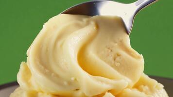 A spoon scooping out a portion of creamy mashed potatoes. Green screen backdrop. Warm, soft lighting to create a comforting feel. video