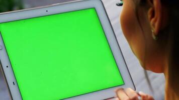 Close up young woman's hand using tablet with green screen. video