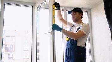 Worker in uniform measures of the vertical deviation of pvc windows video