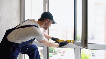 Service man in uniform installs pvc windows in new apartment video