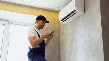Serviceman Setting Temperature Of Air Conditioner Using Smartphone In Hotel video