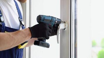 Worker in overalls installing a window lock for home safety. Window Lock How-To. Children s Injury video