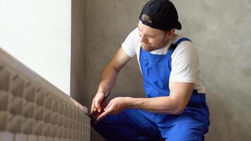 Worker repairing radiator with wrench. Removing air from the radiator and fixing a heating problem. Dismantling and repair of a heating radiator in a house, apartment video