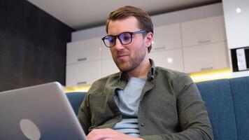 Handsome young male software developer programming codes while working from home video