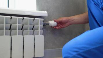 Plumber changes the temperature to a lower temperature with a valve at the radiator. Central heating video