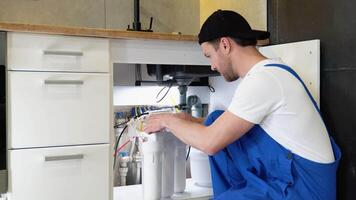 Plumber installs or change water filter. Replacement aqua filter video